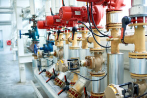 Background image of interior of clean production workshop at modern factory, machine units with red valves and pipes in focus, copy space